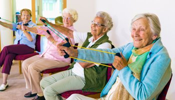 Mehrere Rentnerinnen machen Übung mit einem Fitness-Gerät | © belahoche - Fotolia